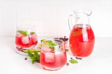 Hibiscus Suyu veya limonata, yaz aşılamalı çiçek suyu buzlu amber çayı, limon dilimleri ve nane, ferahlatıcı ve soğutucu, sağlıklı su, pembe doğal kokteyl.