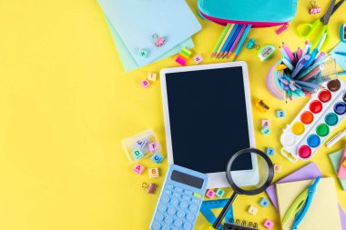 Okulun çeşitli okul gereçleri, öğrenciler ve okul çocukları için eğitim aksesuarları, defterler, kalemler, kalemler, hesap makinesi, kalem kutusu, sırt çantası, kulaklık içeren renkli geçmişine geri dön