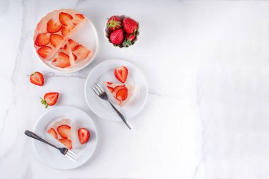 Japon yağmur damlası keki, ya da Mizu Shingen Mochi, berrak jöle tatlısı, kristal berrak su benzeri lezzetli, çilek dilimli tart, tabaklar üzerine porsiyonlu, beyaz mermer arka plan fotokopi alanı