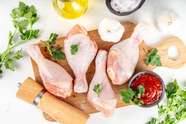 Tavuk eti hazırlama arka planı, ızgaraya hazır çiğ tavuk bacağı, baharatlar, tuz, biber, zeytinyağı, sarımsak ve salamura veya sos. Izgara ve bbq sezon pişirme arka planı, kopyalama alanı