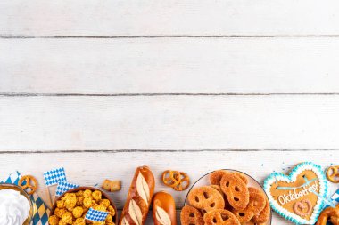 Oktoberfest festival yemekleri, çeşitli atıştırmalıklar, tatlılar, tatlılar, krakerler, bira jölesi, zencefilli kurabiye kalpleri, tuzlanmış krakerler, patlamış mısır, reçelli çörekler, kekler. Oktoberfest brunch menüsü arkaplanı