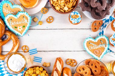 Oktoberfest festival yemekleri, çeşitli atıştırmalıklar, tatlılar, tatlılar, krakerler, bira jölesi, zencefilli kurabiye kalpleri, tuzlanmış krakerler, patlamış mısır, reçelli çörekler, kekler. Oktoberfest brunch menüsü arkaplanı