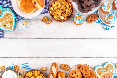 Oktoberfest festival yemekleri, çeşitli atıştırmalıklar, tatlılar, tatlılar, krakerler, bira jölesi, zencefilli kurabiye kalpleri, tuzlanmış krakerler, patlamış mısır, reçelli çörekler, kekler. Oktoberfest brunch menüsü arkaplanı