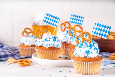 Oktoberfest kekleri tuzlu kraker, krem şanti ve renkli şeker serpintileri, beyaz ahşap arka planda Oktoberfest bayram dekoru, kopyalama alanı