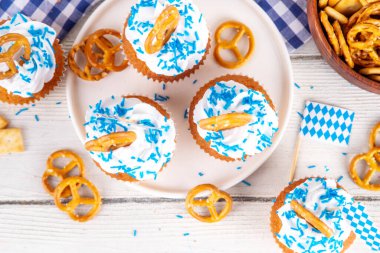 Oktoberfest kekleri tuzlu kraker, krem şanti ve renkli şeker serpintileri, beyaz ahşap arka planda Oktoberfest bayram dekoru, kopyalama alanı