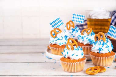 Oktoberfest kekleri tuzlu kraker, krem şanti ve renkli şeker serpintileri, beyaz ahşap arka planda Oktoberfest bayram dekoru, kopyalama alanı