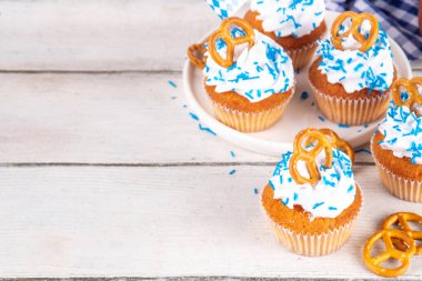Oktoberfest kekleri tuzlu kraker, krem şanti ve renkli şeker serpintileri, beyaz ahşap arka planda Oktoberfest bayram dekoru, kopyalama alanı