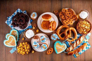 Oktoberfest festival yemekleri, çeşitli atıştırmalıklar, tatlılar, tatlılar, krakerler, bira jölesi, zencefilli kurabiye kalpleri, tuzlanmış krakerler, patlamış mısır, reçelli çörekler, kekler. Oktoberfest brunch menüsü arkaplanı