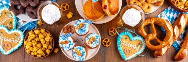 Oktoberfest festival yemekleri, çeşitli atıştırmalıklar, tatlılar, tatlılar, krakerler, bira jölesi, zencefilli kurabiye kalpleri, tuzlanmış krakerler, patlamış mısır, reçelli çörekler, kekler. Oktoberfest brunch menüsü arkaplanı