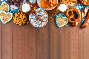 Oktoberfest festival yemekleri, çeşitli atıştırmalıklar, tatlılar, tatlılar, krakerler, bira jölesi, zencefilli kurabiye kalpleri, tuzlanmış krakerler, patlamış mısır, reçelli çörekler, kekler. Oktoberfest brunch menüsü arkaplanı