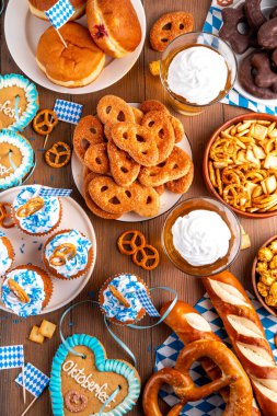 Oktoberfest festival yemekleri, çeşitli atıştırmalıklar, tatlılar, tatlılar, krakerler, bira jölesi, zencefilli kurabiye kalpleri, tuzlanmış krakerler, patlamış mısır, reçelli çörekler, kekler. Oktoberfest brunch menüsü arkaplanı