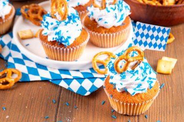 Oktoberfest kekleri tuzlu kraker, krem şanti ve renkli şeker serpintileri, beyaz ahşap arka planda Oktoberfest bayram dekoru, kopyalama alanı