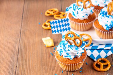 Oktoberfest kekleri tuzlu kraker, krem şanti ve renkli şeker serpintileri, beyaz ahşap arka planda Oktoberfest bayram dekoru, kopyalama alanı