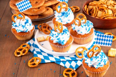 Oktoberfest kekleri tuzlu kraker, krem şanti ve renkli şeker serpintileri, beyaz ahşap arka planda Oktoberfest bayram dekoru, kopyalama alanı