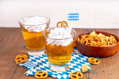 Oktoberfest tatlı fikri, üzerinde krem şanti olan renkli biralı iki bardak altın jöle pudingi, şenlikli Oktoberfest partisi ahşap masa, kopyalama alanı.