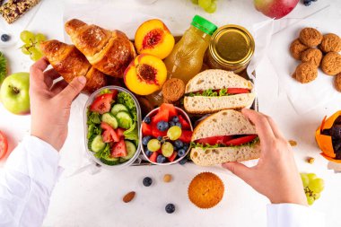 Hazırlık ya da hazır brunch kutusu sandviç, salata, kruvasan, tatlı olarak kurabiye ve meyve suyu, meyve suyu ya da meyve suyu. Kısa bir öğle yemeği molası, zaman tasarrufu, sağlıklı yemek. 