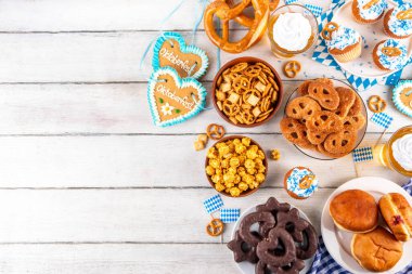 Oktoberfest festival yemekleri, çeşitli atıştırmalıklar, tatlılar, tatlılar, krakerler, bira jölesi, zencefilli kurabiye kalpleri, tuzlanmış krakerler, patlamış mısır, reçelli çörekler, kekler. Oktoberfest brunch menüsü arkaplanı