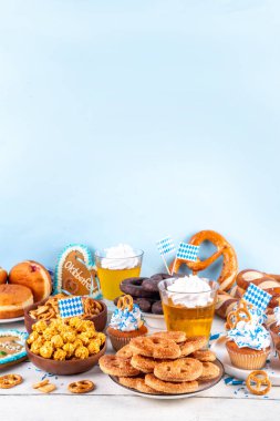 Oktoberfest festival yemekleri, çeşitli atıştırmalıklar, tatlılar, tatlılar, krakerler, bira jölesi, zencefilli kurabiye kalpleri, tuzlanmış krakerler, patlamış mısır, reçelli çörekler, kekler. Oktoberfest brunch menüsü arkaplanı