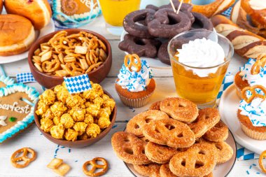 Oktoberfest festival yemekleri, çeşitli atıştırmalıklar, tatlılar, tatlılar, krakerler, bira jölesi, zencefilli kurabiye kalpleri, tuzlanmış krakerler, patlamış mısır, reçelli çörekler, kekler. Oktoberfest brunch menüsü arkaplanı