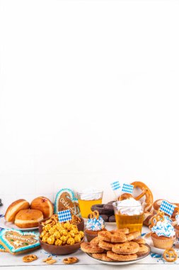 Oktoberfest festival yemekleri, çeşitli atıştırmalıklar, tatlılar, tatlılar, krakerler, bira jölesi, zencefilli kurabiye kalpleri, tuzlanmış krakerler, patlamış mısır, reçelli çörekler, kekler. Oktoberfest brunch menüsü arkaplanı