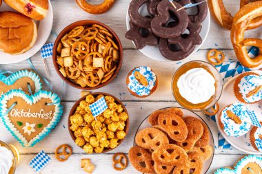 Oktoberfest festival yemekleri, çeşitli atıştırmalıklar, tatlılar, tatlılar, krakerler, bira jölesi, zencefilli kurabiye kalpleri, tuzlanmış krakerler, patlamış mısır, reçelli çörekler, kekler. Oktoberfest brunch menüsü arkaplanı