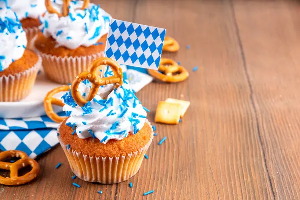 Oktoberfest kekleri tuzlu kraker, krem şanti ve renkli şeker serpintileri, beyaz ahşap arka planda Oktoberfest bayram dekoru, kopyalama alanı