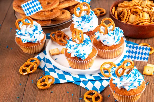 Oktoberfest kekleri tuzlu kraker, krem şanti ve renkli şeker serpintileri, beyaz ahşap arka planda Oktoberfest bayram dekoru, kopyalama alanı