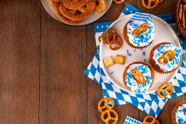 Oktoberfest kekleri tuzlu kraker, krem şanti ve renkli şeker serpintileri, beyaz ahşap arka planda Oktoberfest bayram dekoru, kopyalama alanı