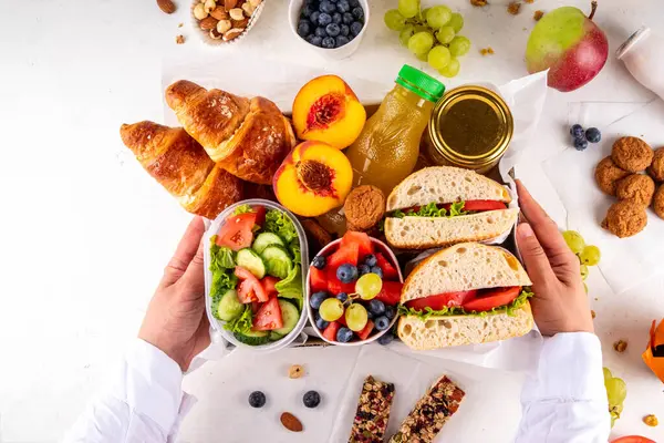 Hazırlık ya da hazır brunch kutusu sandviç, salata, kruvasan, tatlı olarak kurabiye ve meyve suyu, meyve suyu ya da meyve suyu. Kısa bir öğle yemeği molası, zaman tasarrufu, sağlıklı yemek. 