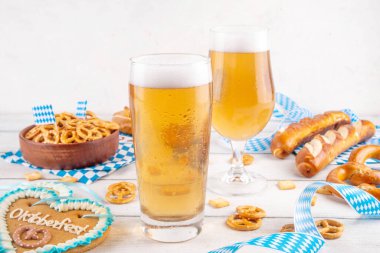 Oktoberfest tebrik kartı geçmişinde iki bira bardağı, tuzlu atıştırmalık ve kraker var. Oktoberfest barı, beyaz ahşap masa üzerindeki kafe menüsü, Ekim Festivali tarzı kareli peçete ve dekorla