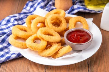 Ketçap soslu altın soğan halkaları, uçak fritözü beyaz ahşap masa fotokopi alanında lezzetli soğan halkaları atıştırmalıkları.