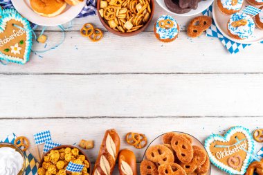 Oktoberfest festival yemekleri, çeşitli atıştırmalıklar, tatlılar, tatlılar, krakerler, bira jölesi, zencefilli kurabiye kalpleri, tuzlanmış krakerler, patlamış mısır, reçelli çörekler, kekler. Oktoberfest brunch menüsü arkaplanı