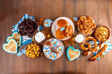 Oktoberfest festival yemekleri, çeşitli atıştırmalıklar, tatlılar, tatlılar, krakerler, bira jölesi, zencefilli kurabiye kalpleri, tuzlanmış krakerler, patlamış mısır, reçelli çörekler, kekler. Oktoberfest brunch menüsü arkaplanı