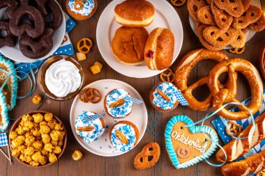 Oktoberfest festival yemekleri, çeşitli atıştırmalıklar, tatlılar, tatlılar, krakerler, bira jölesi, zencefilli kurabiye kalpleri, tuzlanmış krakerler, patlamış mısır, reçelli çörekler, kekler. Oktoberfest brunch menüsü arkaplanı