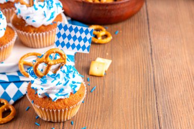 Oktoberfest kekleri tuzlu kraker, krem şanti ve renkli şeker serpintileri, beyaz ahşap arka planda Oktoberfest bayram dekoru, kopyalama alanı