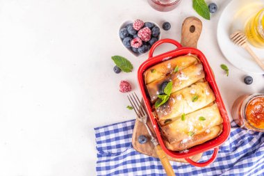 Geleneksel Alman Pfannkuchen-Auflauf, fırında krep güveci. Kahvaltı için tatlı güveç. Krem peynirli krep, taze dut ve pudra şekerli.
