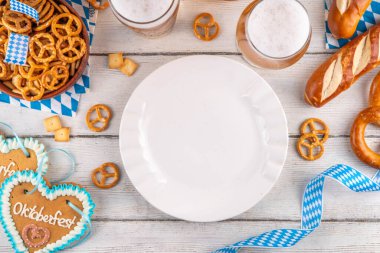 Oktoberfest tebrik kartı geçmişinde iki bira bardağı, tuzlu atıştırmalık ve kraker var. Oktoberfest barı, beyaz ahşap masa üzerindeki kafe menüsü, Ekim Festivali tarzı kareli peçete ve dekorla