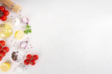 Baharatlar, karabiber, sarımsak, soğan, yeşillik ve domates, beyaz yemek masasında zeytin yağı. Beyaz taş arkaplanda yemek pişirmek için gerekli malzemeler..