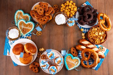 Oktoberfest festival yemekleri, çeşitli atıştırmalıklar, tatlılar, tatlılar, krakerler, bira jölesi, zencefilli kurabiye kalpleri, tuzlanmış krakerler, patlamış mısır, reçelli çörekler, kekler. Oktoberfest brunch menüsü arkaplanı