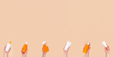 Yaz tatili güneş koruması konsepti. Kadın eli, çocuk eli, farklı tüpler, kavanozlar, şişeler, güneş kremi ürünleri. Kimyasal ve doğal SPF ürünleri, UVA UVB güneşi arka planı korur
