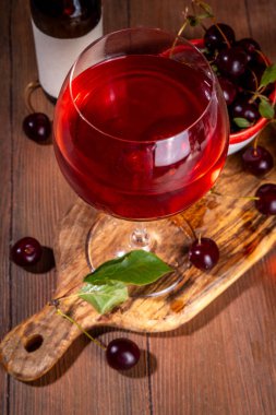 Tatlı alkollü kiraz şarabı, ev yapımı kiraz şarabı ya da taze kirazlı likör mutfak masasında fotokopi alanı.