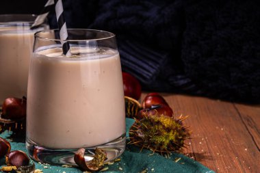 Kestane likörü. Baharatlı baharatlı kremalı içecek çırpılmış kestane, tarçın, baharat, ahşap kırsal arka planda fotokopi alanı.