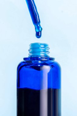 Metilen mavi serum, yüz bakımı için yaşlanmayı önleyici kozmetik serum. Mavi cam serum şişeleri ve damlaları. Modern cilt bakımı, güzellik ritüelleri, viral kozmetik tedaviler.
