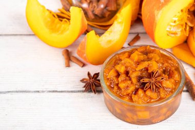 Ev yapımı tatlı sonbahar balkabağı Chutney, kahverengi şekerli, tarçınlı, beyaz ahşap zemin üzerinde - kabak kabağı, baharatlar, bal