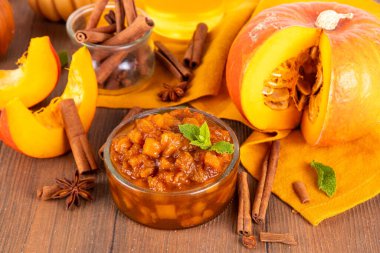Ev yapımı tatlı sonbahar balkabağı Chutney, kahverengi şekerli, tarçınlı, beyaz ahşap zemin üzerinde - kabak kabağı, baharatlar, bal