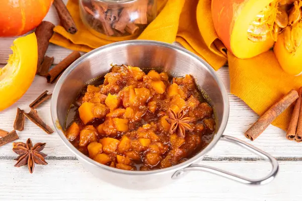 Ev yapımı tatlı sonbahar balkabağı Chutney, kahverengi şekerli, tarçınlı, beyaz ahşap zemin üzerinde - kabak kabağı, baharatlar, bal
