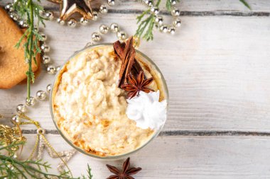 Noel Yüksek Proteinli Eggnog Gece Yulafı, çırpılmış krema ve baharatla, Xmas dekore edilmiş arka planda, lezzetli tatlı yumurta nog yulaf ezmesi tarifi fikri