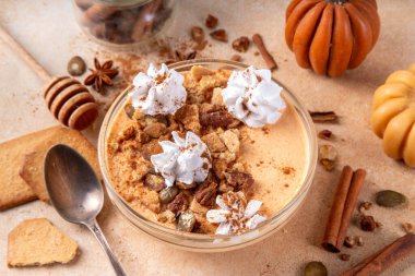 Balkabağı turtası Yunan Yoğurtlu kahvaltı kasesi kabak püresi ve tohumlu fındık ezmesi, fındıklı kraker, krema ve tarçınlı, lezzetli sonbahar atıştırmalığı veya kahvaltı tarifi