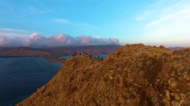Komodo Ulusal Parkı üzerinde gün doğumunun sakin bir görüntüsü, sabahın erken saatlerinde parkların ve suların dramatik doğal güzelliğini gözler önüne seriyor..