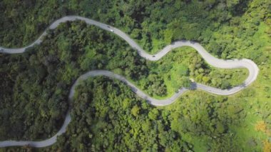 Chiang Mai, Tayland 'da dolambaçlı bir dağ yolunu gösteren çarpıcı bir hava görüntüsü. Video dağlık arazinin yemyeşil ve manzaralı güzelliğini gözler önüne seriyor..